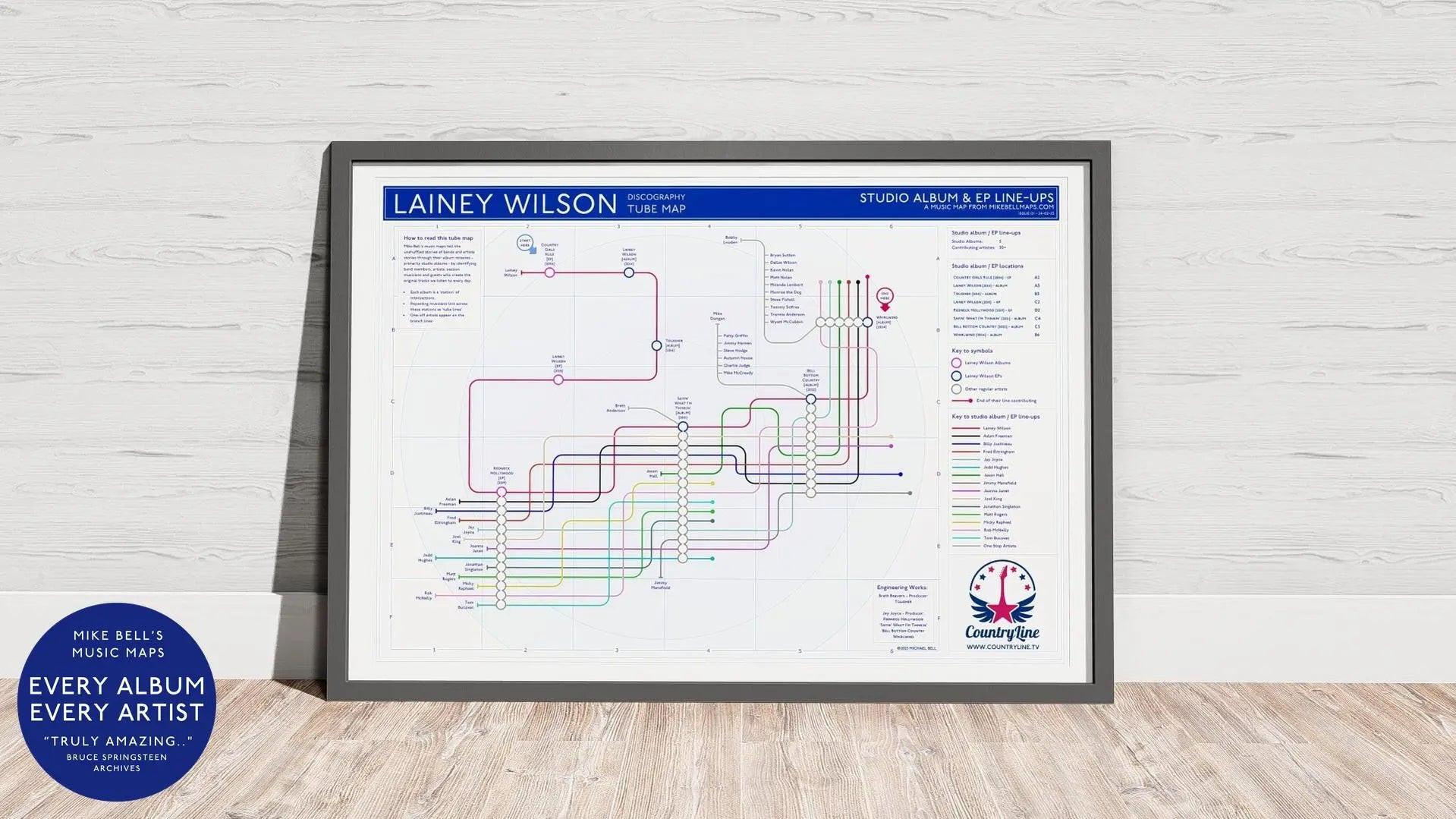 Lainey Wilson discography map wall art print in a black A1 landscape frame, hung on a feature wall, showing every studio album in order including Bell Bottom Country, designed by Mike Bell at mikebellmaps.com.