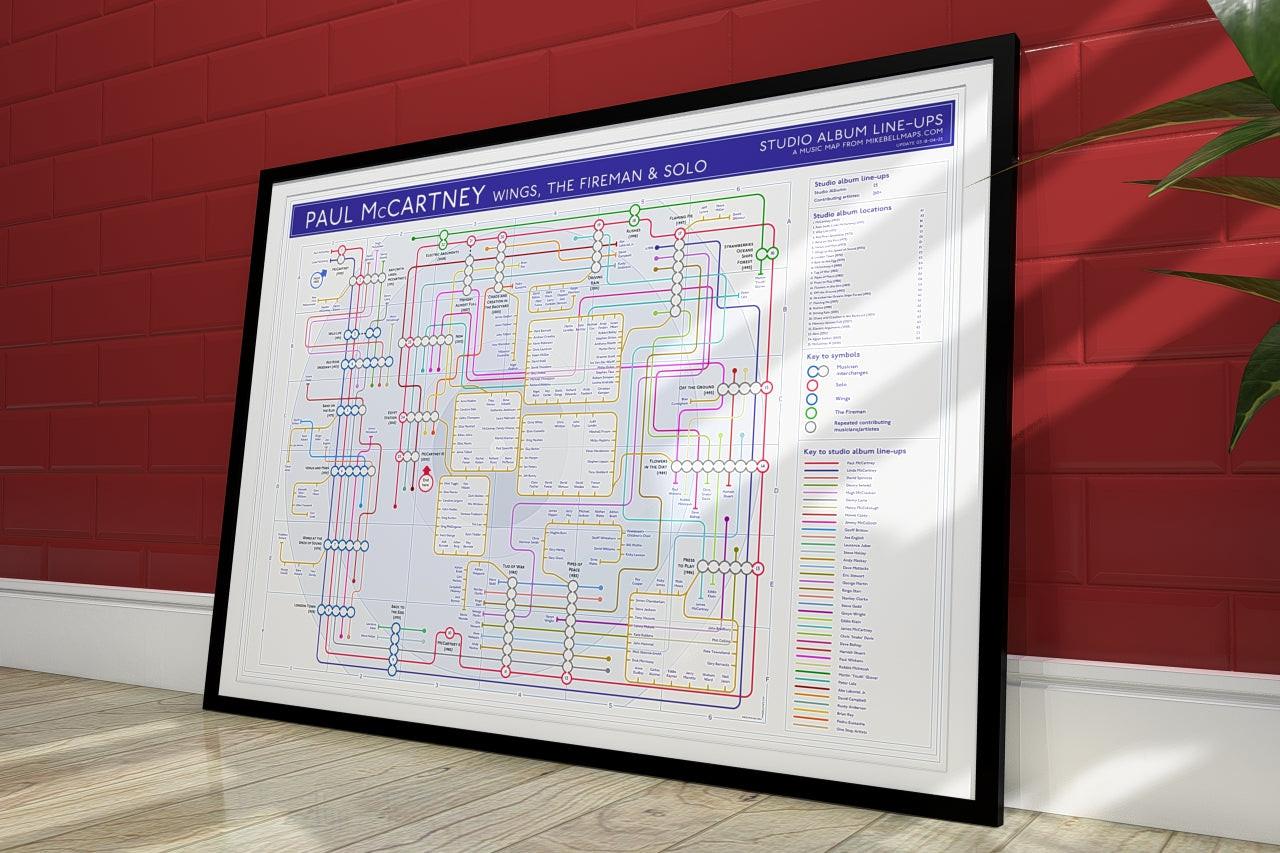 Paul McCartney discography map wall art print in a black A1 landscape frame, hung on a feature wall, showing every solo and Wings studio album in order, designed by Mike Bell at mikebellmaps.com.
