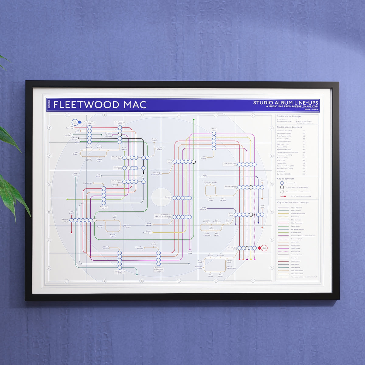 Fleetwood Mac discography tube map hung in an A1 black wooden frame on a plain wall, landscape Giclée wall art print, designed by Mike Bell.