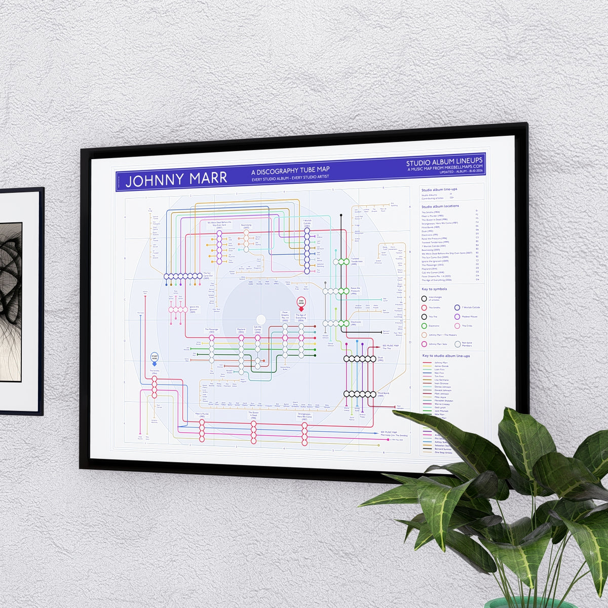 Johnny Marr discography tube map in A2, framed Giclée wall art print hung on a wall, by Mike Bell.