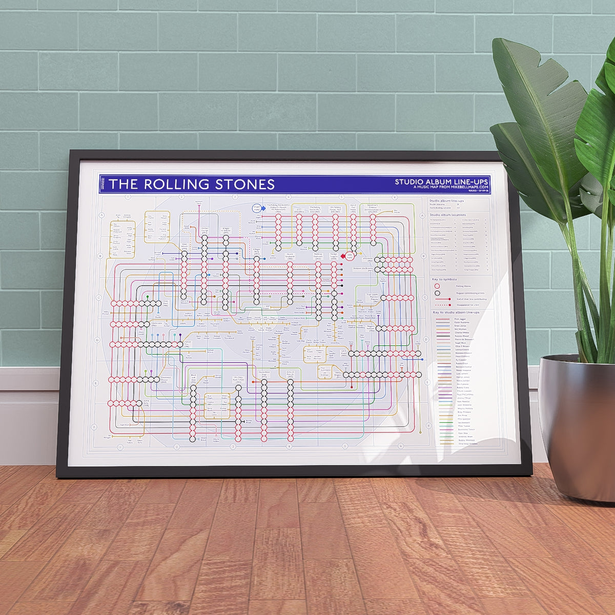 Framed art print gift for Rolling Stones fans - The Rolling Stones discography tube map in A1 size, framed Giclée wall art print propped against a wall on the floor, by Mike Bell.