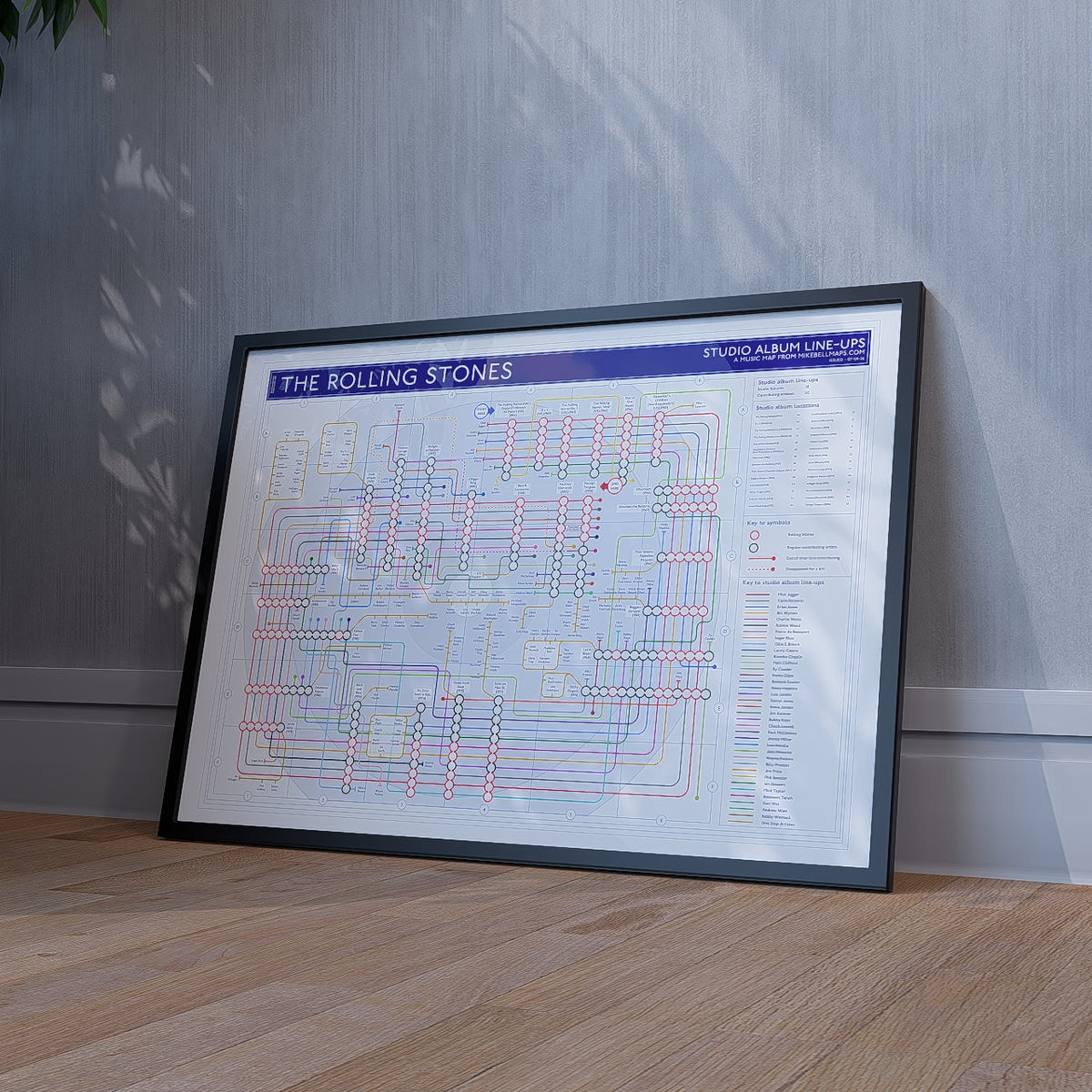 Framed art print gift for Rolling Stones fans - The Rolling Stones discography tube map in A1 size, framed Giclée wall art print propped against a wall on the floor, by Mike Bell.