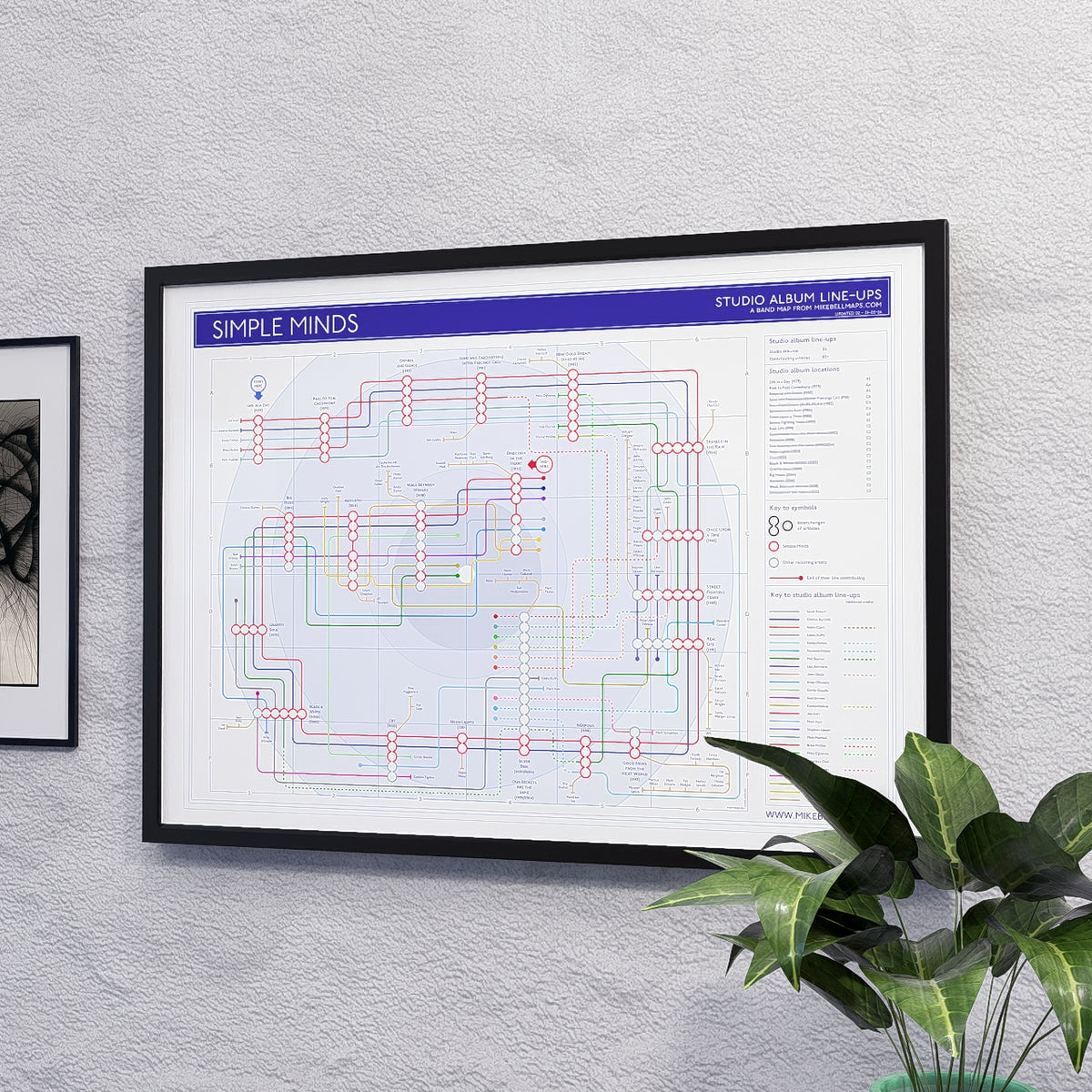 Simple Minds discography map art print in A2 (594 x 420 mm) in a black wood frame, designed by Mike Bell.