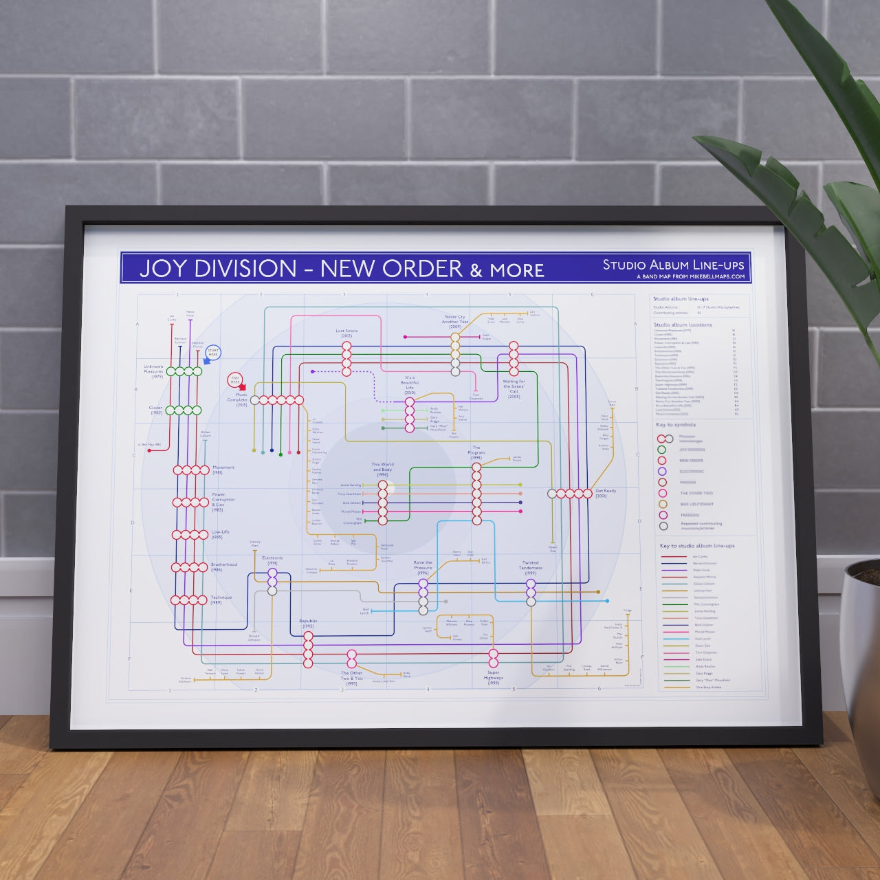 Gift for New Order fans - A1 framed Giclée discography tube map art print hung on a feature wall, with every credited musician drawn as a named tube line calling at the albums they played on, designed and researched by Mike Bell at mikebellmaps.com