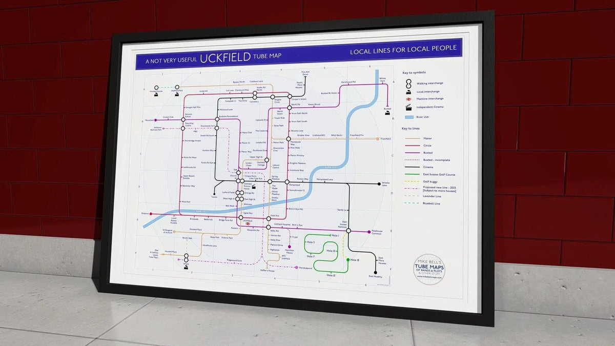 The Uckfield tube map art print in an A1 black wood frame, hung on a wall, showing the East Sussex town drawn as a London Underground style network, designed by Mike Bell