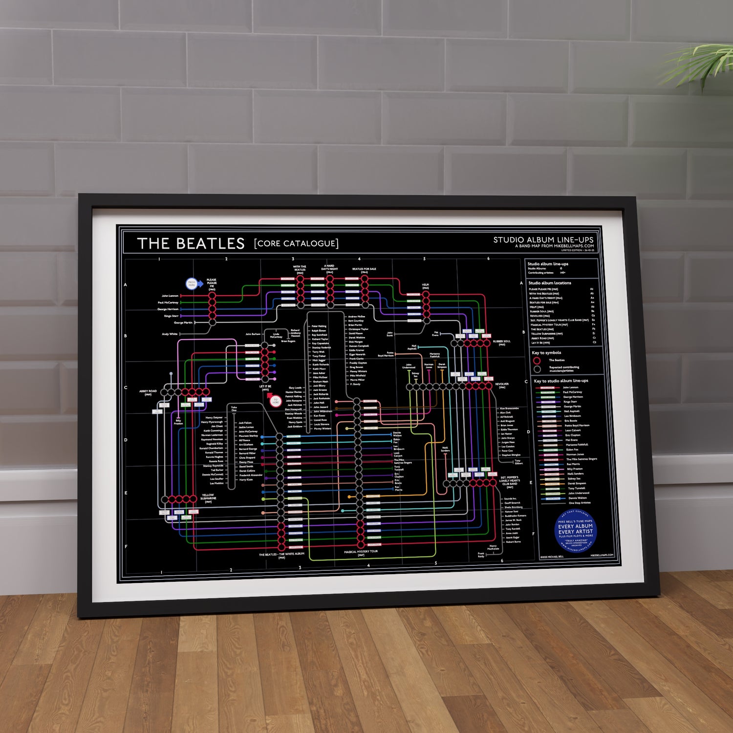 The Beatles Black Edition discography map framed on a wall showing every studio album in order, designed by Mike Bell.