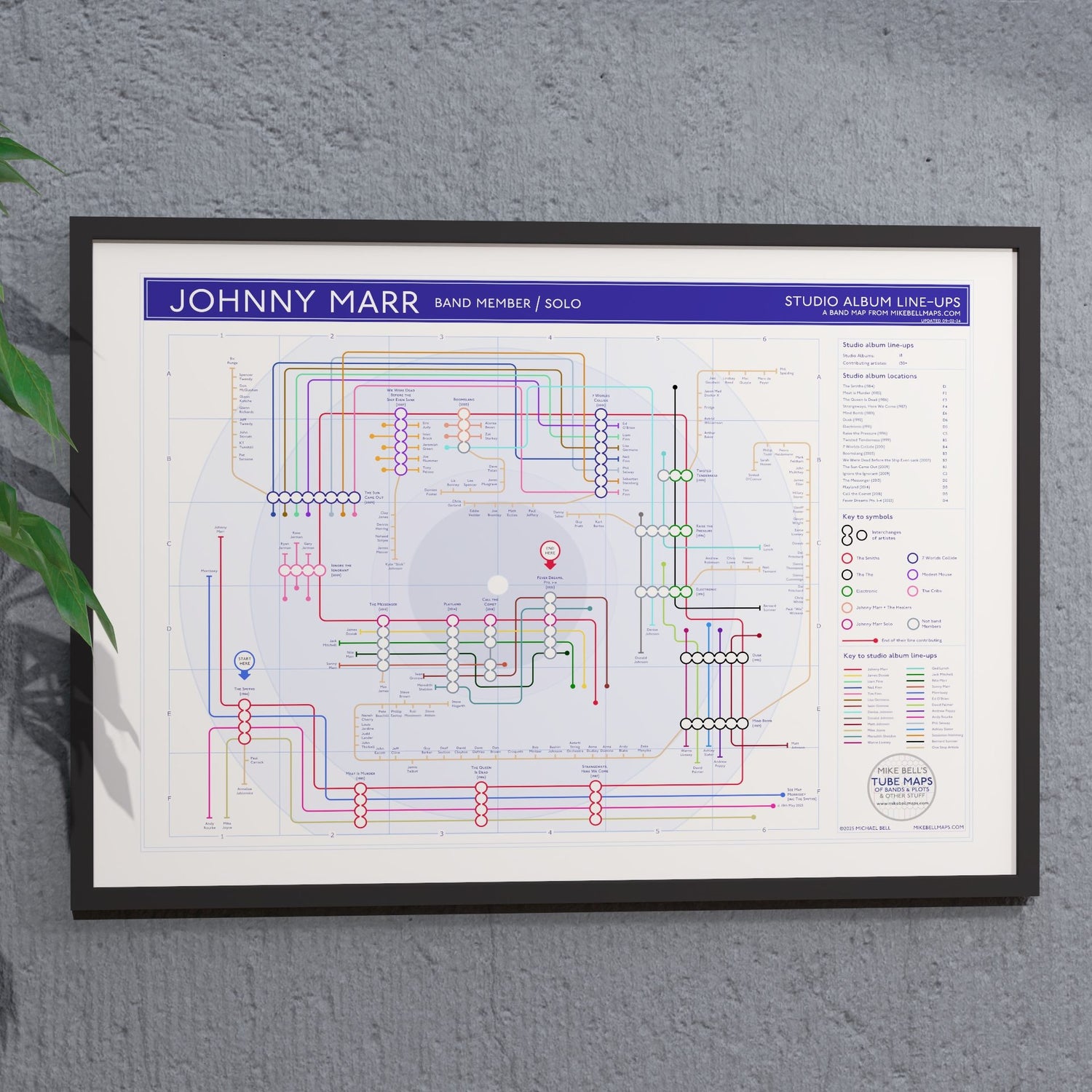 Johnny Marr discography tube map hung in an A1 black wooden frame on a plain wall, landscape Giclée wall art print, designed by Mike Bell.