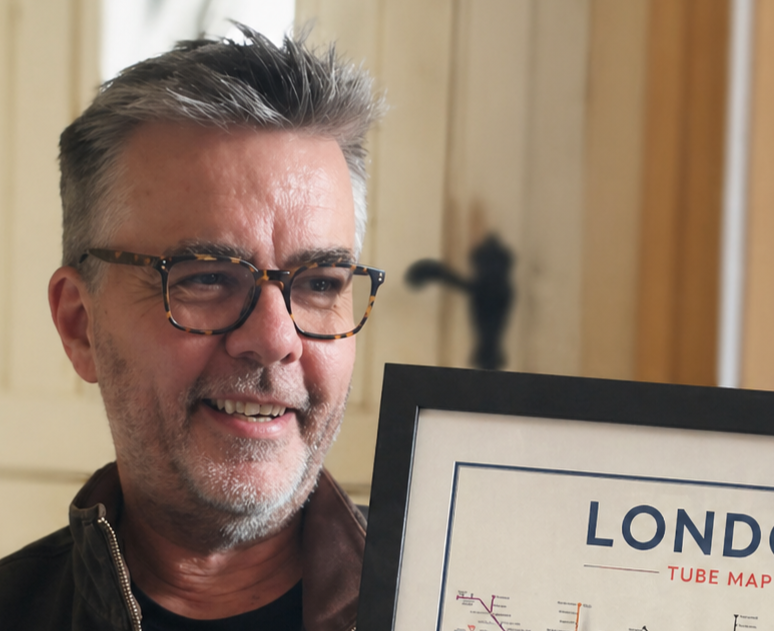 Mike Bell holding a framed tube map