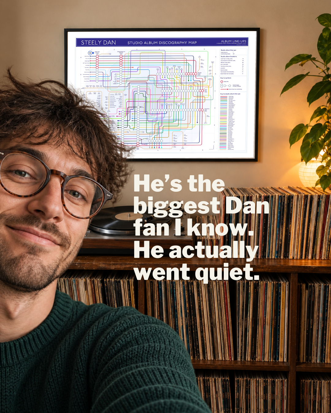 A man in a room with vinyl records, with a framed Steely Dan music map art print on the wall behind him and large overlaid text.